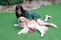 Portrait of cute woman playing with dog on green grass Royalty Free Stock Photo