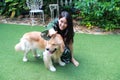 Portrait of cute woman playing with dog on green grass Royalty Free Stock Photo