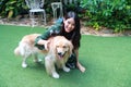 Portrait of cute woman playing with dog on green grass Royalty Free Stock Photo