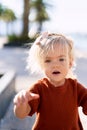 A portrait of a cute 2-year old girl in a terracotta dress and pink bow in her hair Royalty Free Stock Photo