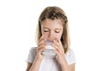 Portrait of a cute 7 years old girl Isolated over white background with milk glass Royalty Free Stock Photo