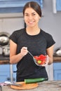 Portrait of cute young asian girl smiling while cooking salad with fresh vegetables in kitchen interior at home Royalty Free Stock Photo