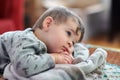 a Portrait of a cute young boy watching tv whith his safety blanket