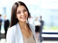 Portrait of a cute young business woman smiling, in an office environment Royalty Free Stock Photo