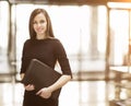 Portrait of cute young business woman smiling in the office, the hands of the folder Royalty Free Stock Photo
