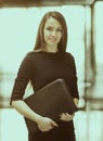 Portrait of cute young business woman smiling in the office, the hands of the folder Royalty Free Stock Photo