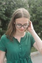 Portrait of cute young girl with eyeglasses, smiling. Blonde hair, natural, beautiful teen age girl. Summer portrait Royalty Free Stock Photo