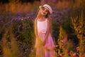 Portrait of cute young girl with long hair in a hat at sunset in the field Royalty Free Stock Photo