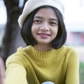 Portrait cute young girl smiling wear hat and yellow swater at park. Royalty Free Stock Photo