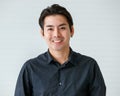 Portrait of a cute young and handsome Asian man in casual shirt pose to camera with warm smile and self trust