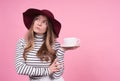 Portrait of a cute young lady in a fashionablea hat with a cup and saucer Royalty Free Stock Photo