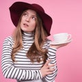 Portrait of a cute young lady in a fashionablea hat with a cup and saucer Royalty Free Stock Photo