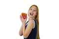 A portrait of a cute young red-haired girl who stands half-turn and holds a small box with a gift on her face with both Royalty Free Stock Photo