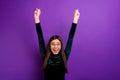 Portrait of cute youth raising fists screaming shouting yeah wearing eyeglasses eyewear isolated over purple violet Royalty Free Stock Photo