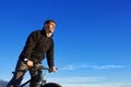 Portrait of cyclist seen from below with blue sky.