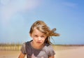 portrait of a pretty little girl with windy hair on the beach in summer Royalty Free Stock Photo