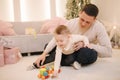 Portrait of dad and son in Christmas time. Happy family spent time together during the holiday. Boy play with toys with Royalty Free Stock Photo