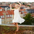Portrait, dance and smile with a woman on a roof in her neighborhood for energy or freedom in summer. Music, movement