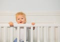 Portrait of a dancing toddler boy in the baby crib
