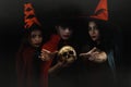 Portrait on dark background of man in vampire costume with two women in witch costume for halloween party with human Royalty Free Stock Photo