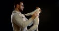 Portrait of a dark-haired man with a middle-aged beard, holding his small dog in his hands, scolding it, shaking it Royalty Free Stock Photo