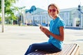 Portrait of dark-haired teenage girl sitting with smartphone on Royalty Free Stock Photo