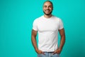 Portrait of a dark-skinned cheerful smiling man against turquoise background