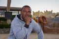 Portrait of a dark-skinned man of 40 years on an open tourist beach against the background of lifebuoys, close-up. Perhaps he work