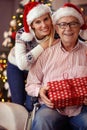 portrait of daughter and elderly father in wheelchair celebrating Christmas.