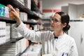 Dedicated pharmacist taking a medicine from the shelf during work Royalty Free Stock Photo