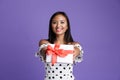 Portrait of a delighted asian woman standing isolated over violet background