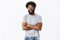 Portrait of delighted calm and handsome african american male coworker in glasses with tattoos and pierced nose smiling Royalty Free Stock Photo