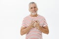 Portrait of delighted and grateful cute mature grandfather feeling like heart melting from sincere happiness holding Royalty Free Stock Photo