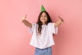 Little girl in party cone giving free hugs with outstretched hands, welcoming inviting to embrace. Royalty Free Stock Photo
