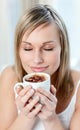 Portrait of a delighted woman drinking a coffee