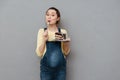 Portrait of a delighted young pregnant woman eating chocolate cake Royalty Free Stock Photo