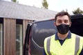 Portrait Of Delivery Driver Wearing Mask Next To Van Outside House Royalty Free Stock Photo