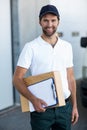 Portrait of delivery man is holding cardboard box and posing Royalty Free Stock Photo
