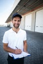 Portrait of delivery man is holding a clipboard and smiling to the camera Royalty Free Stock Photo