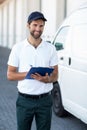 Portrait of delivery man is holding a clipboard and smiling to the camera Royalty Free Stock Photo