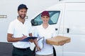 Portrait of delivery man and woman standing with clipboard and parcel