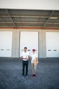 Portrait of delivery man and woman standing with clipboard and parcel