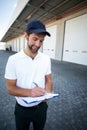 Portrait of delivery man is writing something on a clipboard Royalty Free Stock Photo