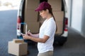 Portrait of delivery woman is writing something on a clipboard Royalty Free Stock Photo