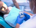 Portrait of a dentist who treats teeth of young woman patient