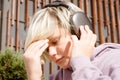 Portrait of depressed caucasian teenager boy with headache listening to music on wireless headphones Royalty Free Stock Photo