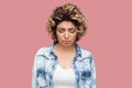 Portrait of depressed sad alone young woman with curly hairstyle in casual blue shirt standing, closed eyes and holding head down Royalty Free Stock Photo