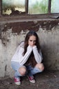 Portrait of depressed young girl leaning on wall of ruined building Royalty Free Stock Photo