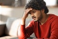 Portrait Of Depressed Young Indian Man Sitting On Couch At Home Royalty Free Stock Photo