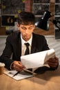 Portrait of detective working at desk in his office, detective office interior with workplace and investigation board Royalty Free Stock Photo